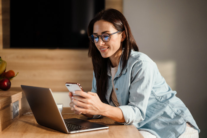 woman-smiling-while-texting-on-smartphone