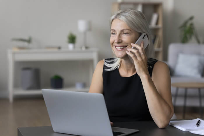 middle-aged-woman-speaking-on-the-phone-with-laptop